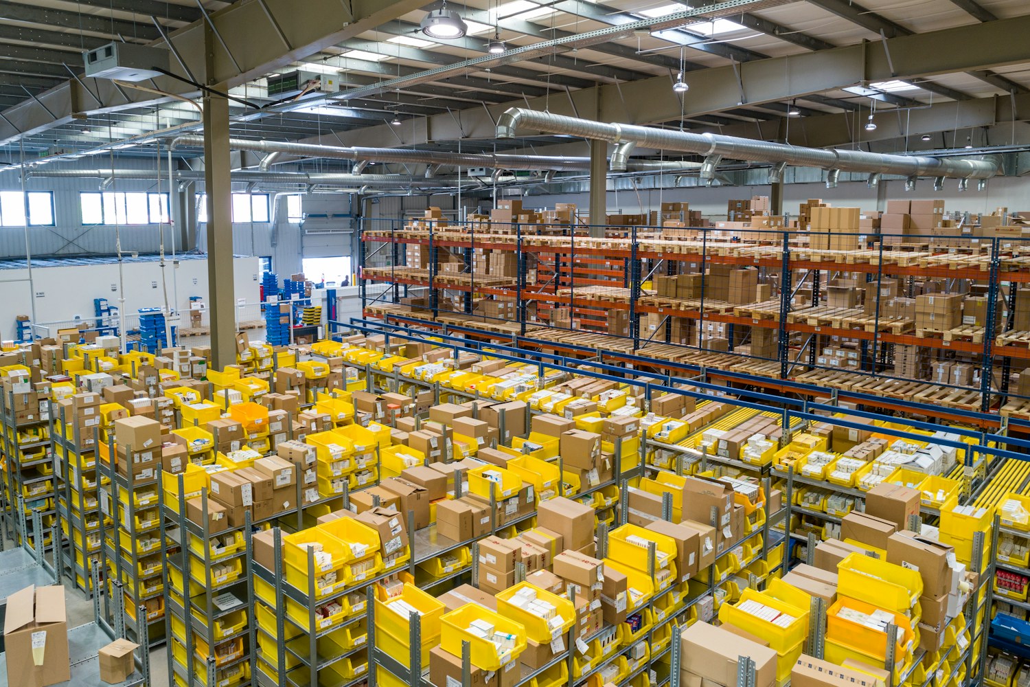 Warehouse shelves and parcels across an active distribution floor